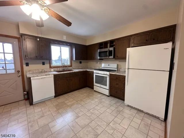 a kitchen with stainless steel appliances granite countertop a refrigerator stove a sink dishwasher and a refrigerator