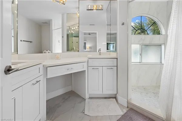 a spacious bathroom with a granite countertop sink a mirror and a shower