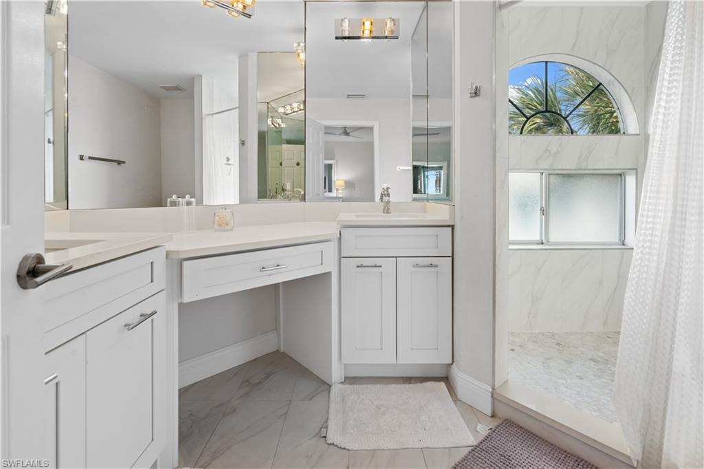 2711 Citrus Lake Drive, Unit F302 Naples, FL 34109 - Photo 7 of 20 a spacious bathroom with a granite countertop sink a mirror and a shower