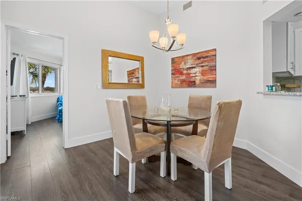 a view of a dining room with furniture wooden floor and chandelier