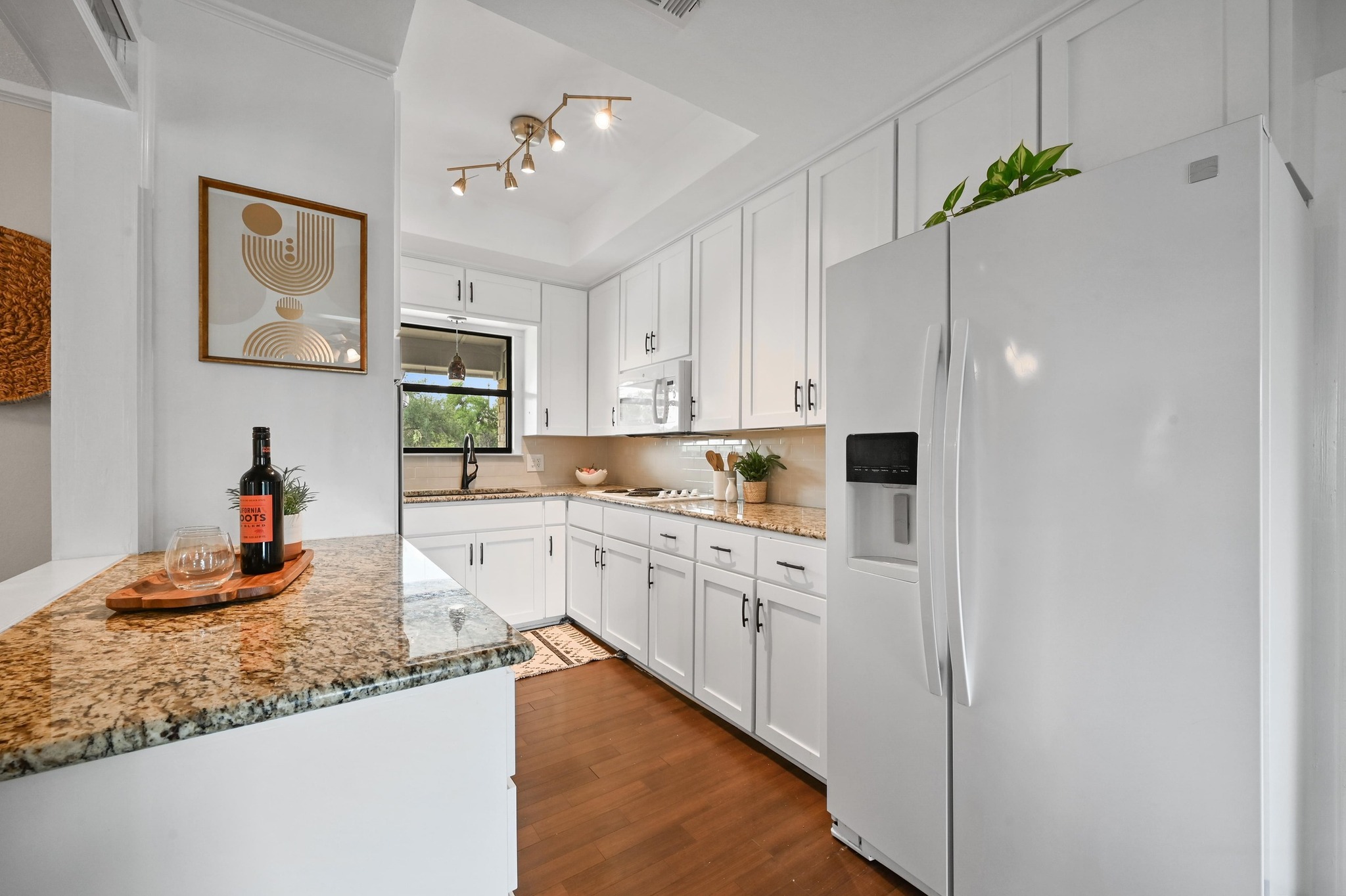 2018 Chaparral Park Road Manchaca, TX 78652 - Photo 9 of 26 a kitchen with kitchen island granite countertop cabinets and white appliances