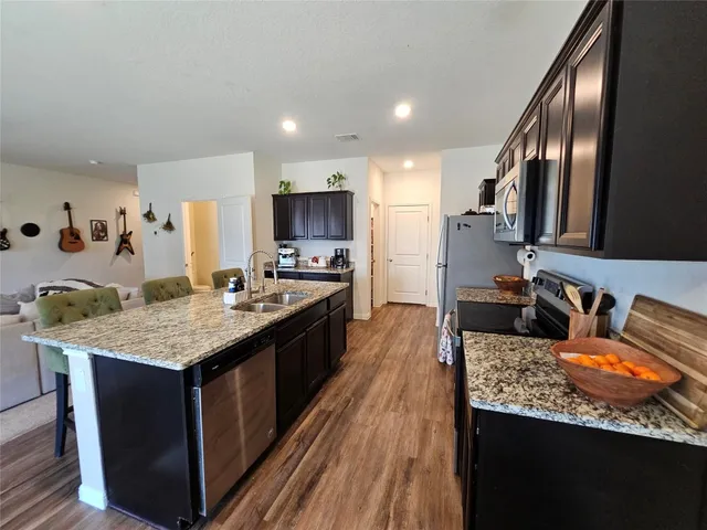 a large kitchen with a center island and stainless steel appliances