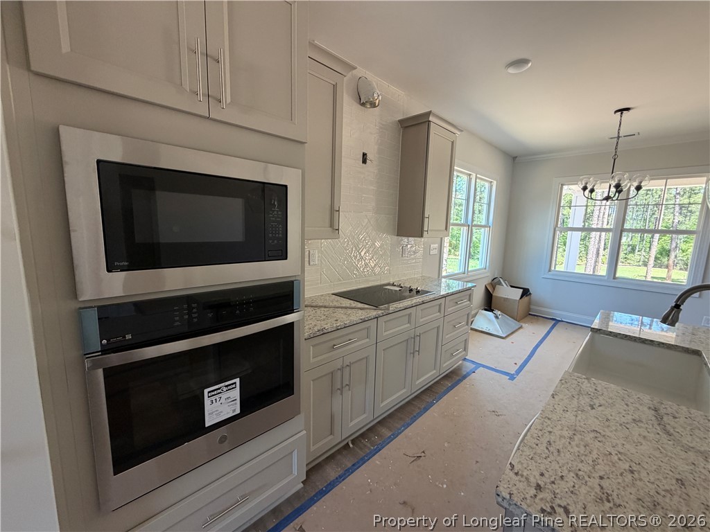 930 Rhum Drive Fayetteville, NC 28311 - Photo 17 of 49 a kitchen with stainless steel appliances granite countertop a stove a sink and a microwave