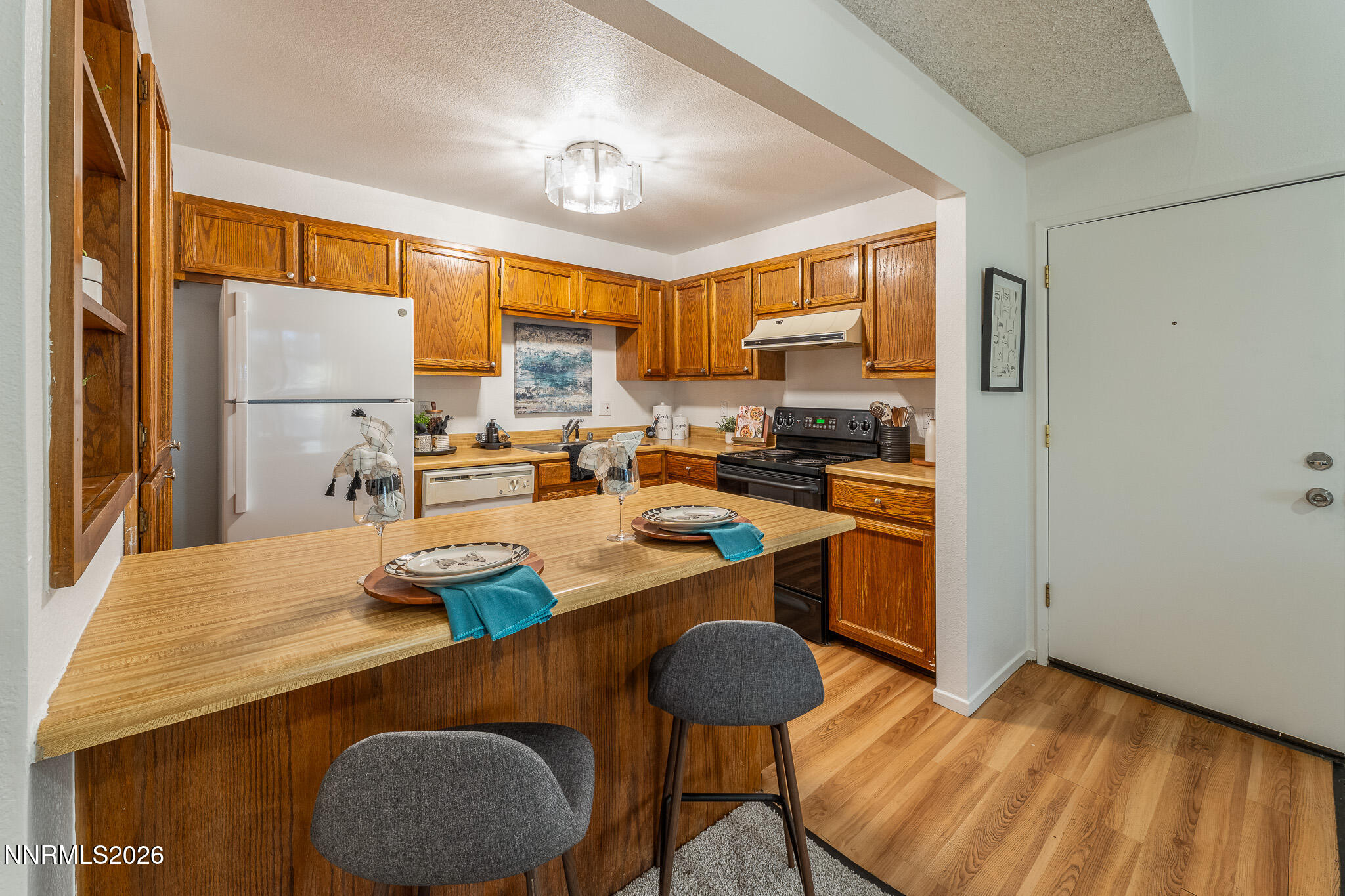 1465 East Peckham Lane, Unit 6 Reno, NV 89502 - Photo 4 of 25 a kitchen with a table chairs and a refrigerator