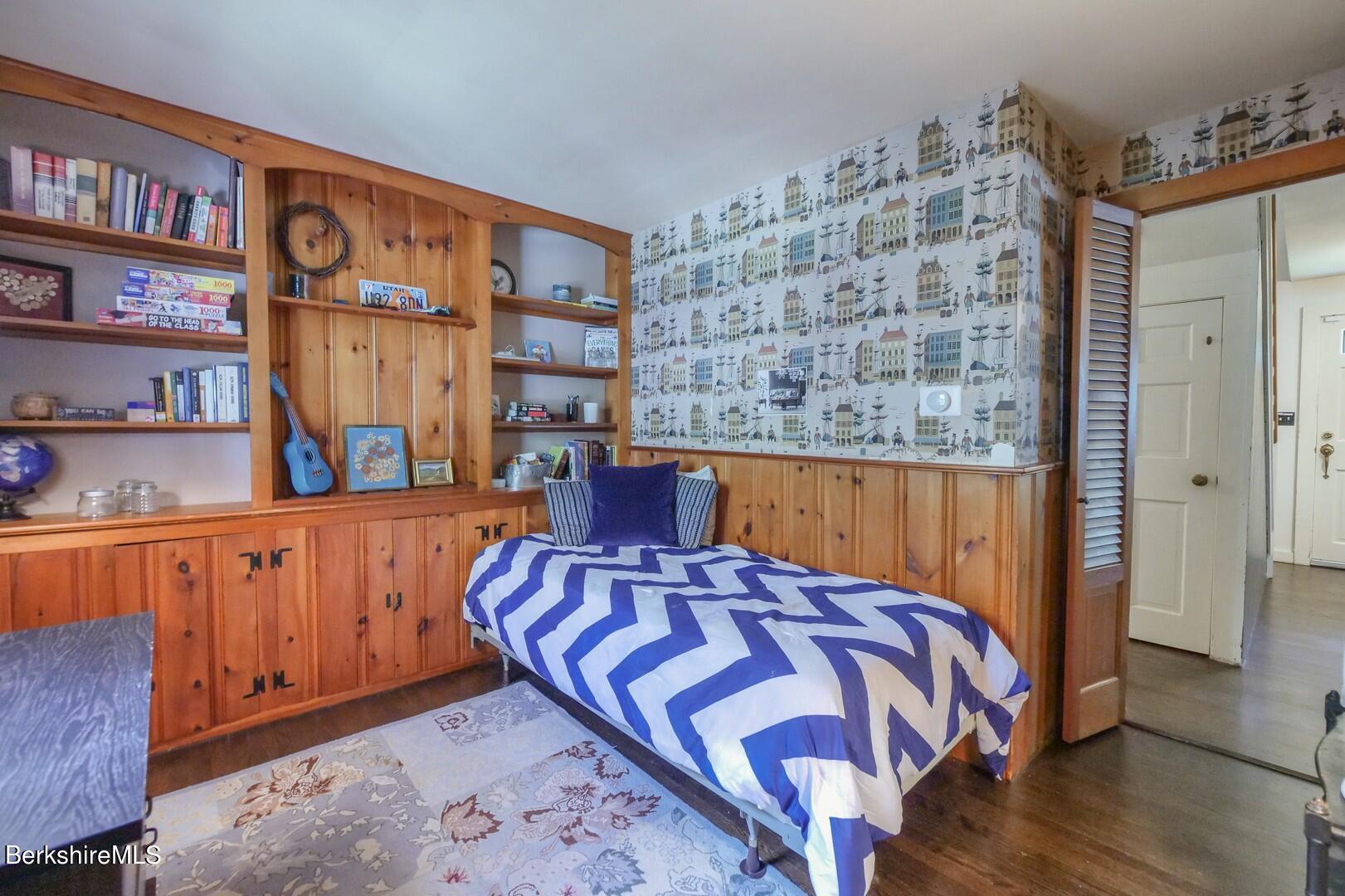6 Interlaken Road Stockbridge, MA 01262 - Photo 18 of 28 a bed sitting in a bedroom next to a book shelf