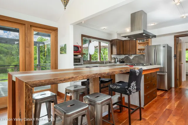 a kitchen with a table chairs refrigerator and window