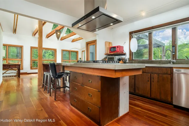a kitchen with stainless steel appliances granite countertop a stove and a wooden floors