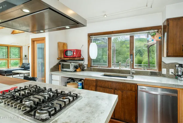 a kitchen with a large window and stainless steel appliances