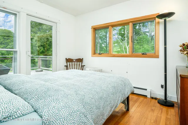 a bedroom with a bed and a large window