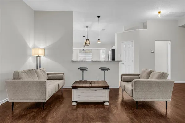 a living room with furniture and a wooden floor