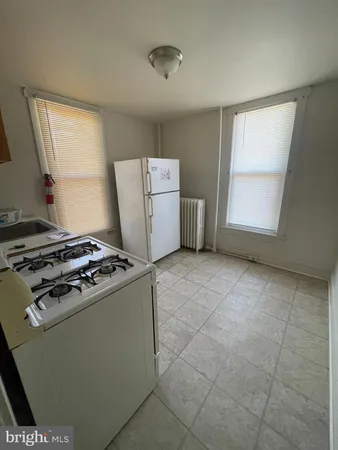 a kitchen with a stove a fridge and a window