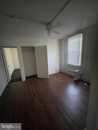 a view of a livingroom with wooden floor and window