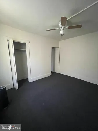 an empty room with a ceiling fan and closet