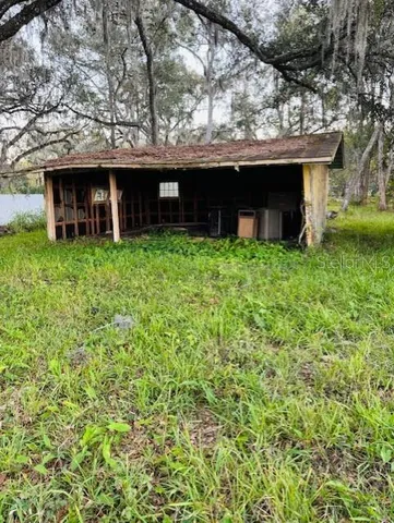 a view of a house with a yard and a large tree