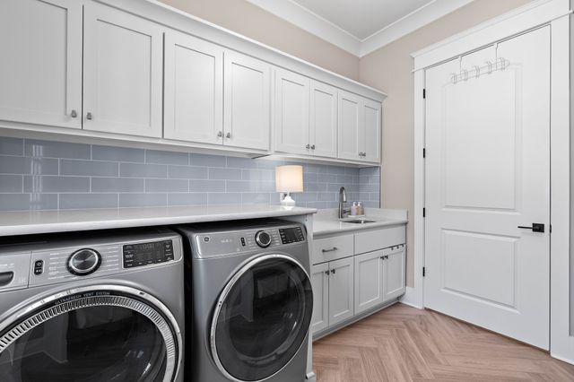 a utility room with sink dryer and washer