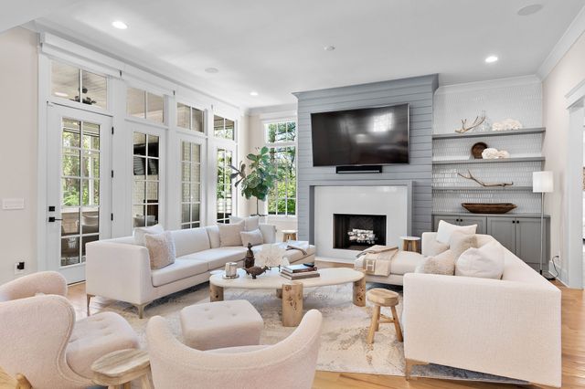 a living room with furniture a flat screen tv and a fireplace