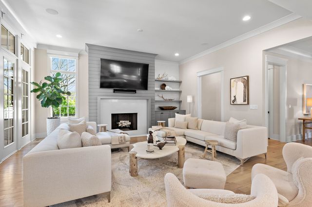 a living room with furniture white walls and white kitchen view