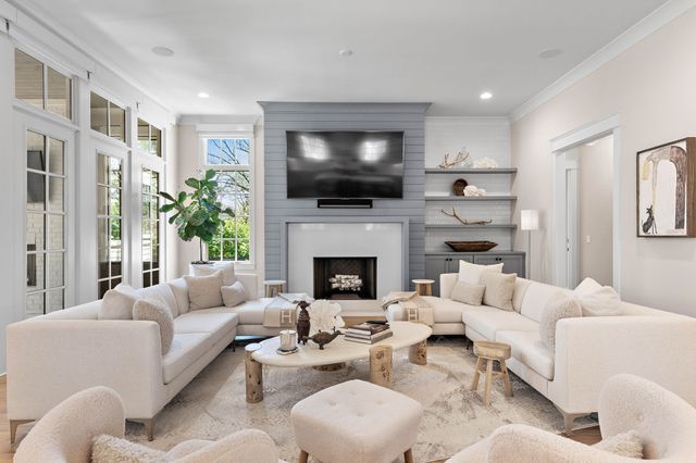 a kitchen with stainless steel appliances granite countertop a sink a stove a refrigerator cabinets and a dining table with wooden floor