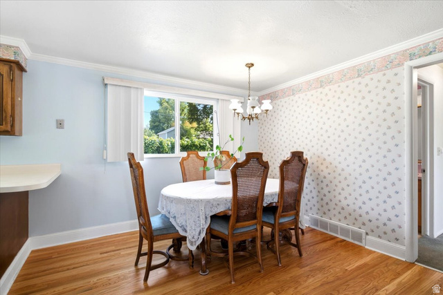 272 East 1400th Street North Bountiful, UT 84010 - Photo 13 of 38 Dining area with wood-finish flooring, a brass chandelier, and vintage wallpaper with a floral border