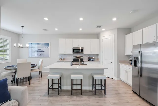 a kitchen with refrigerator and chairs