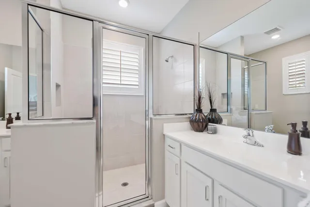 a bathroom with a double vanity sink toilet mirror and bathtub