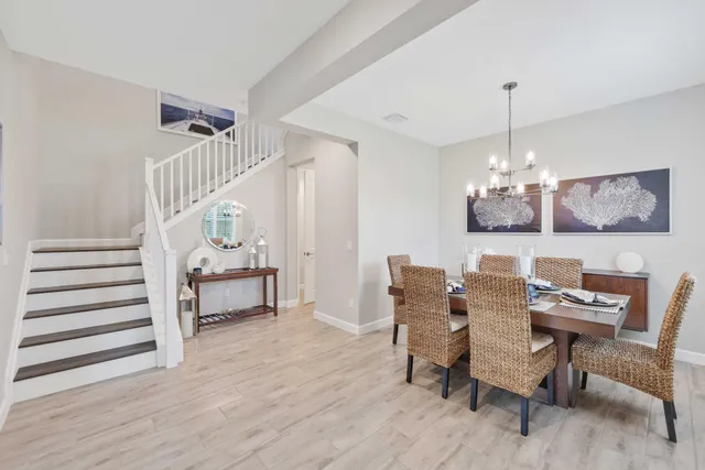 a dining room with furniture a chandelier and wooden floor
