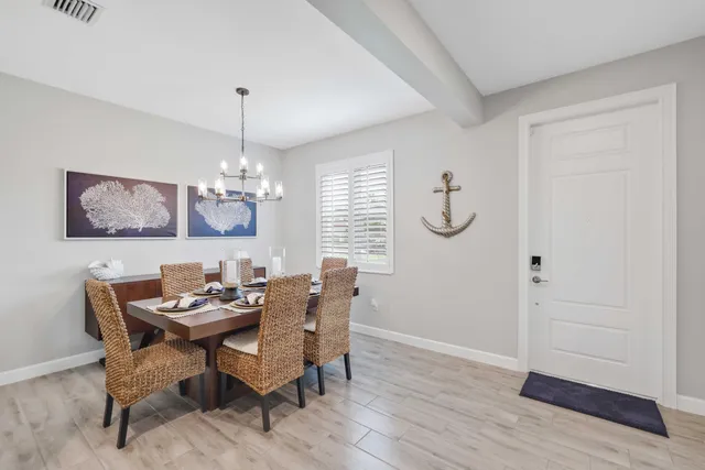 a dining room with furniture a chandelier and wooden floor