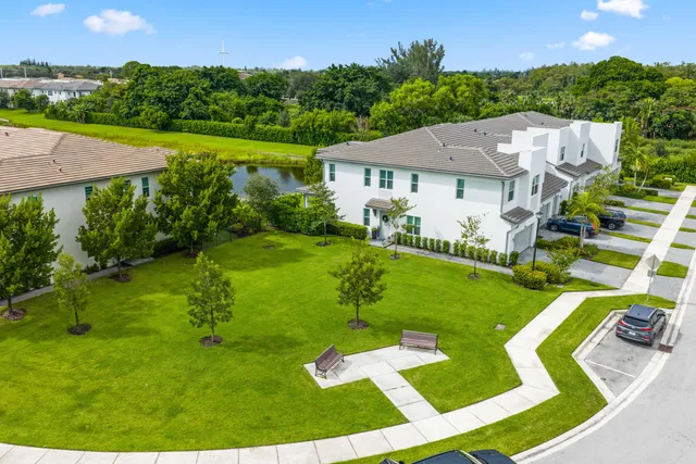 a living room with furniture a flat screen tv and floor to ceiling window