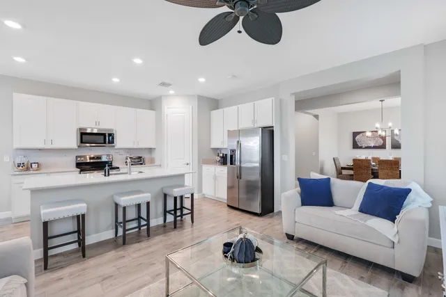 a living room with furniture a refrigerator and kitchen view