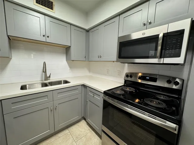 a kitchen with stainless steel appliances a stove microwave and sink