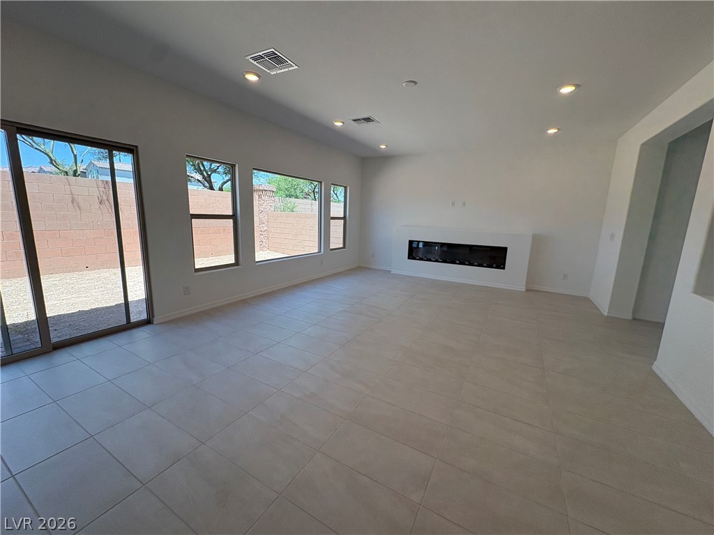 8677 South Indigo Springs Road Las Vegas, NV 89139 - Photo 9 of 9 Bright, naturally illuminated living space features sleek tile flooring and a modern linear fireplace.