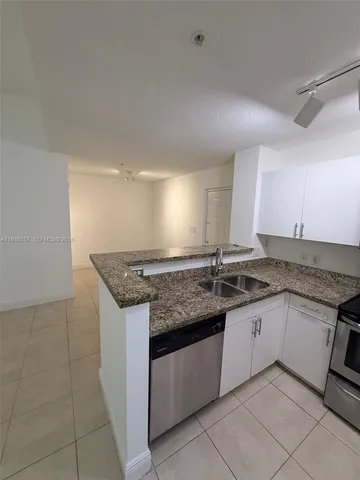 a kitchen with granite countertop a sink and cabinets