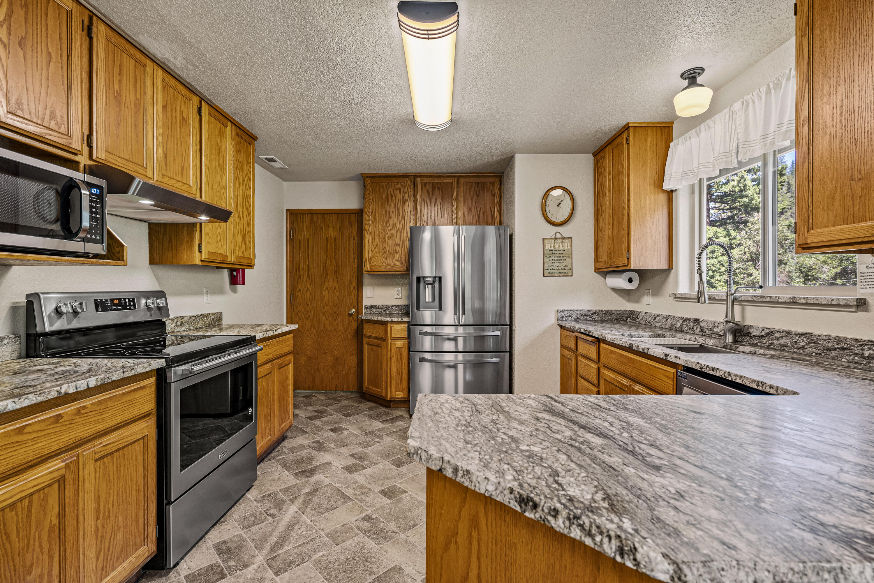 11744 Galice Road Merlin, OR 97532 - Photo 24 of 74 a kitchen with stainless steel appliances granite countertop a stove a sink and a refrigerator