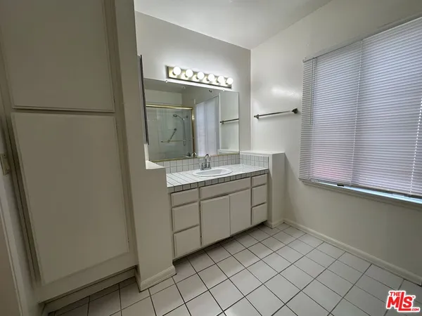 a bathroom with a sink a mirror and a shower