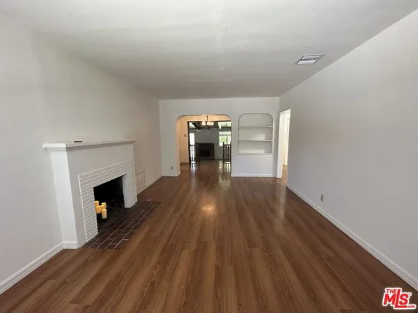 a view of a livingroom with wooden floor and a fireplace