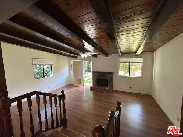 a view of empty room with wooden floor and fireplace