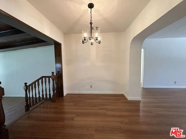 a view of a room with wooden floor and white walls