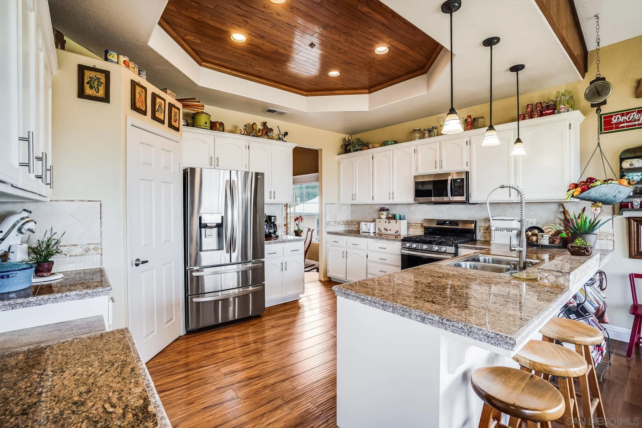 2366 Highview Lane Spring Valley, CA 91977 - Photo 17 of 53 a kitchen with stainless steel appliances granite countertop a refrigerator a oven a sink a dining table and chairs with wooden floor