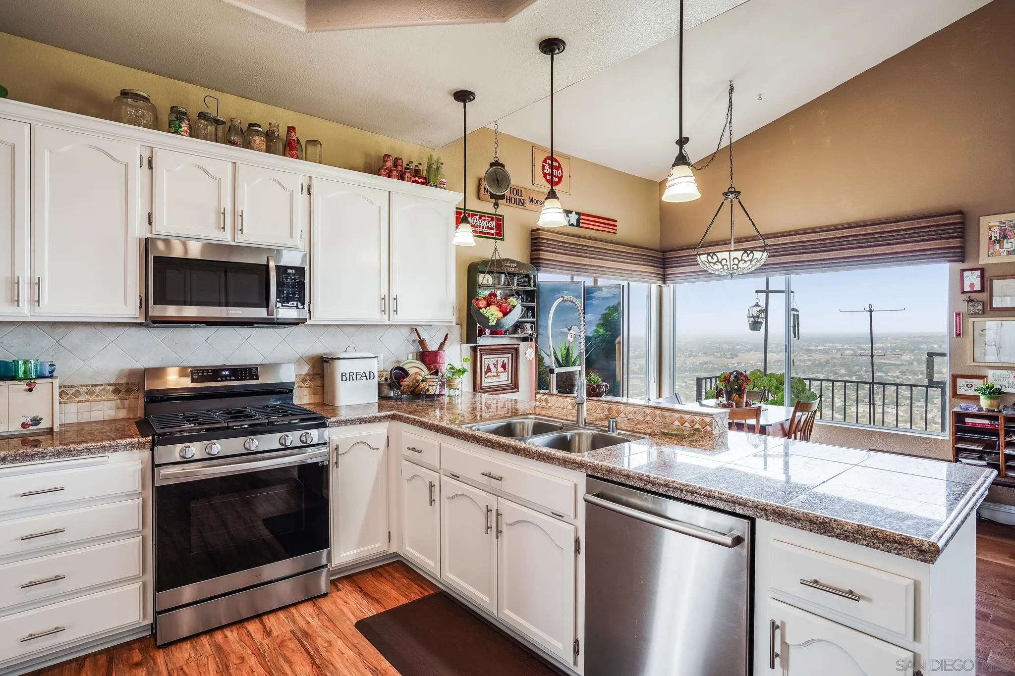 2366 Highview Lane Spring Valley, CA 91977 - Photo 19 of 53 a kitchen with stainless steel appliances granite countertop a sink a stove and a wooden floors