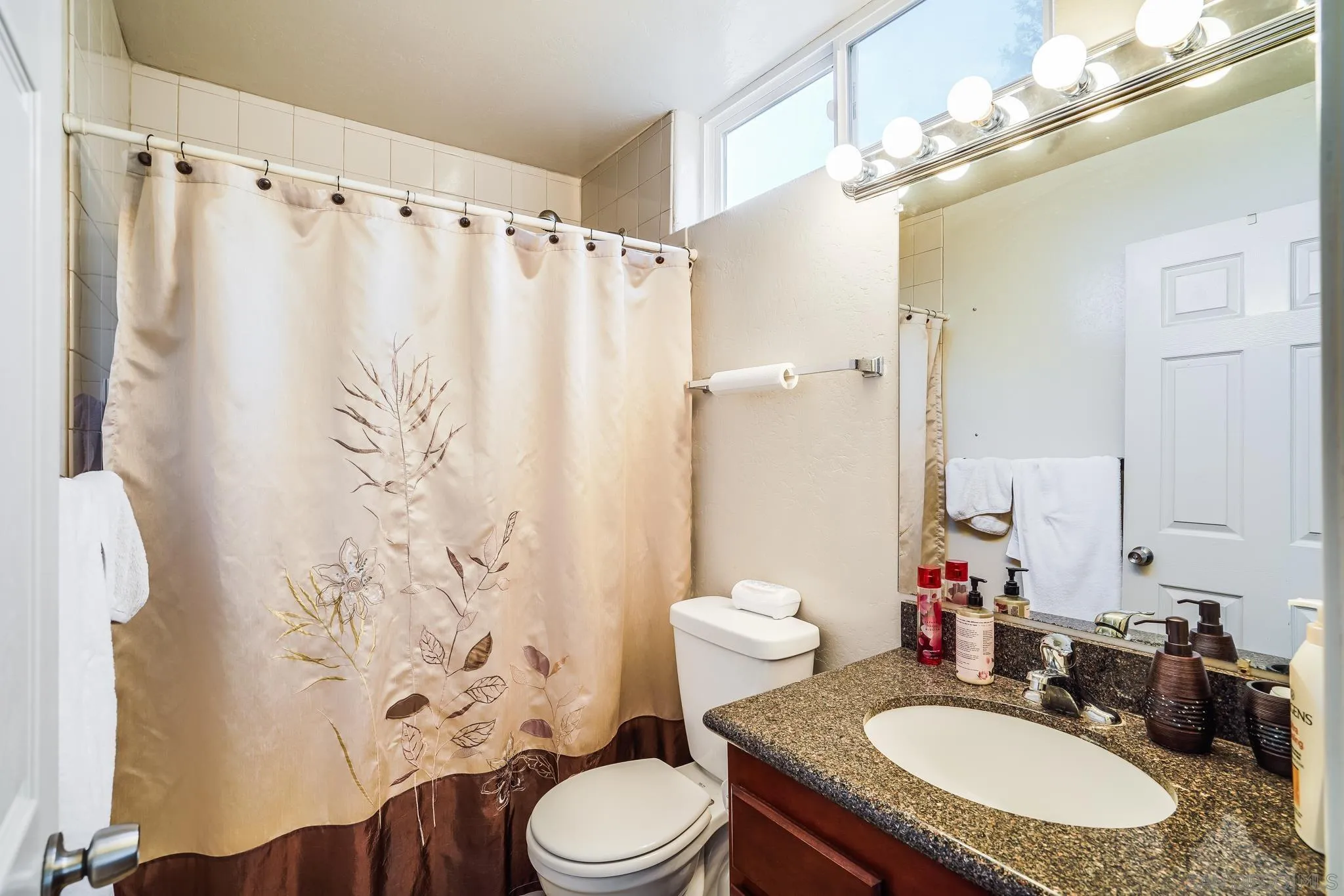 2366 Highview Lane Spring Valley, CA 91977 - Photo 42 of 53 a bathroom with a granite countertop sink toilet a mirror a vanity and shower curtain