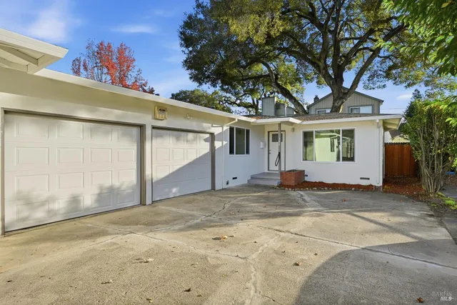 a view of a house with a tree in front of it