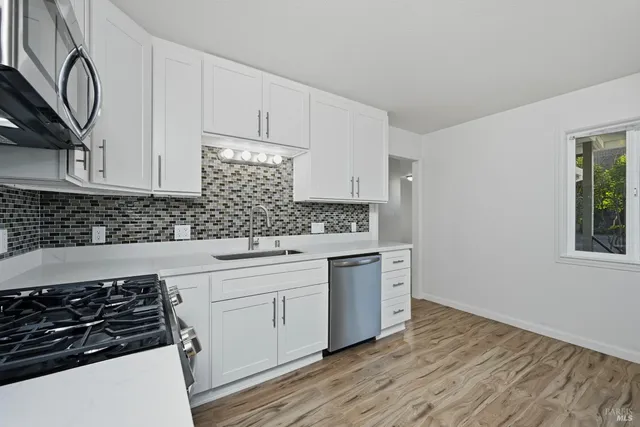 a kitchen with granite countertop white cabinets and appliances