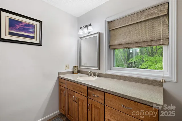 a bathroom with a sink a large mirror and a window