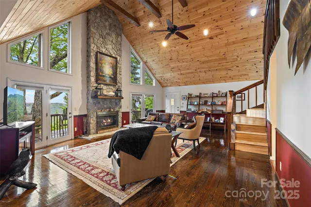 a living room with furniture a rug and a floor to ceiling window