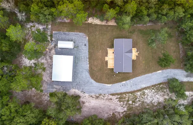 a view of a house with a big yard and large trees
