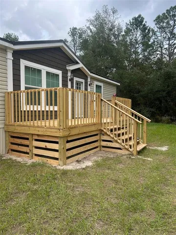 a view of a wooden balcony and trees