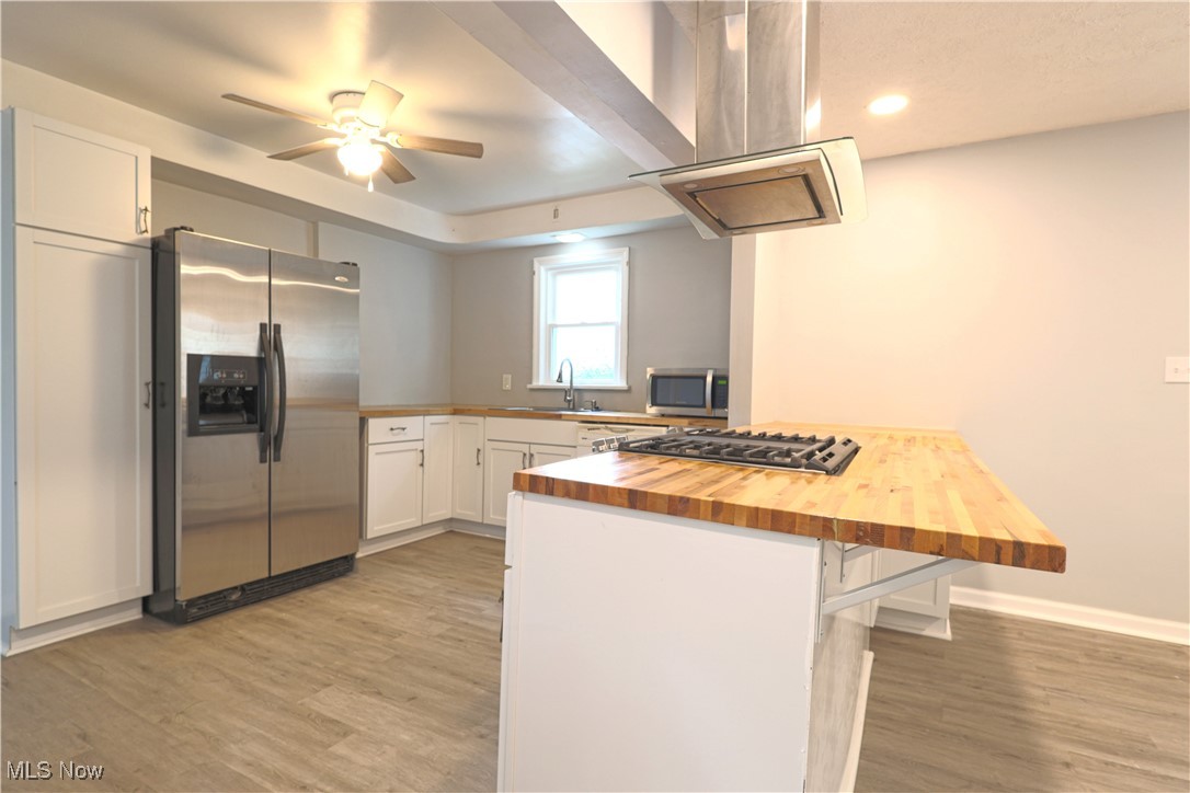 1332 South Green Road South Euclid, OH 44121 - Photo 6 of 23 Kitchen featuring wood counters, stainless steel appliances, white cabinets, a peninsula, and island exhaust hood