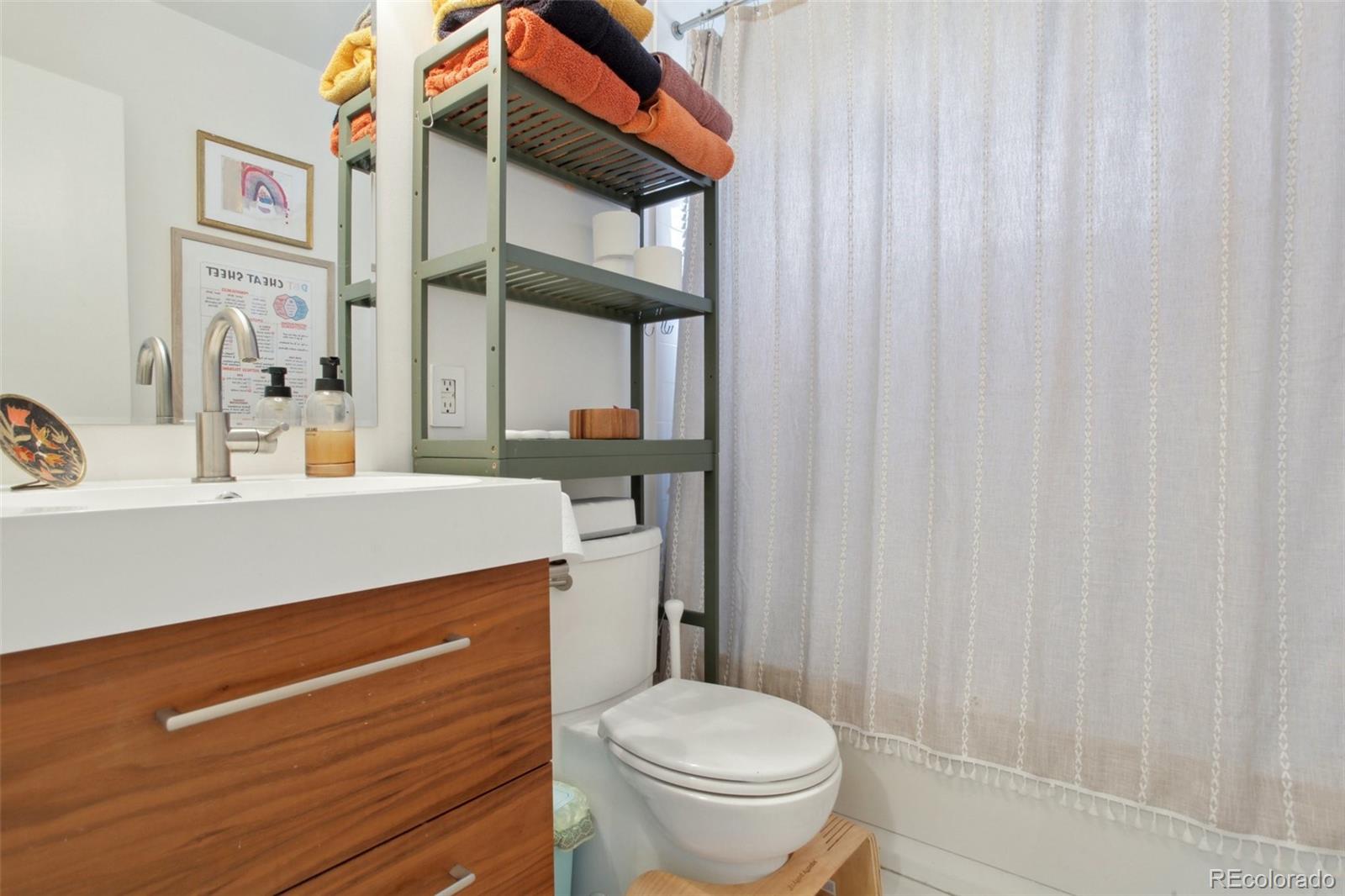 7130 West 30th Avenue Wheat Ridge, CO 80033 - Photo 17 of 37 a bathroom with a sink a toilet and shower curtain