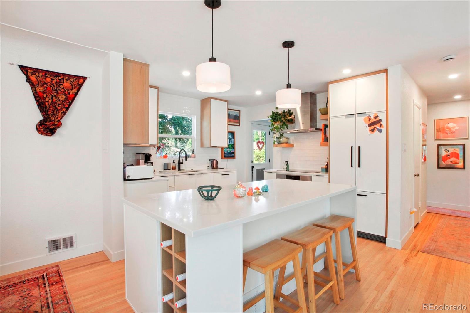 7130 West 30th Avenue Wheat Ridge, CO 80033 - Photo 10 of 37 a kitchen with stainless steel appliances a stove a sink dishwasher a refrigerator a dining table and chairs with wooden floor