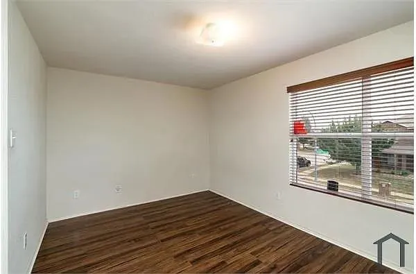 a view of a room with wooden floor and windows